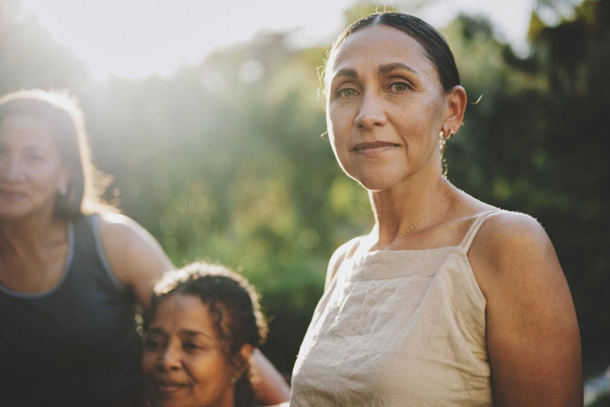 mature woman sitting with others outdoors during a wellness retreat
