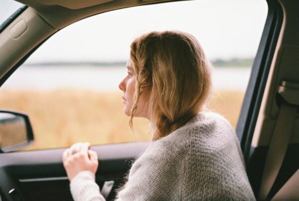 woman thinking from afar inside the car
