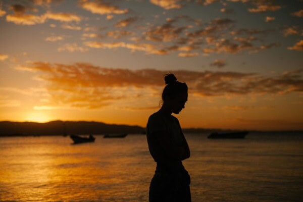 woman standing thinking sunset