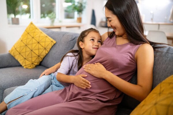 pregnant mother and her daughter spending time together at home