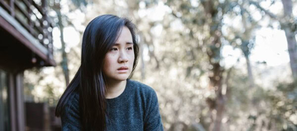 woman outside the house while holding a mug