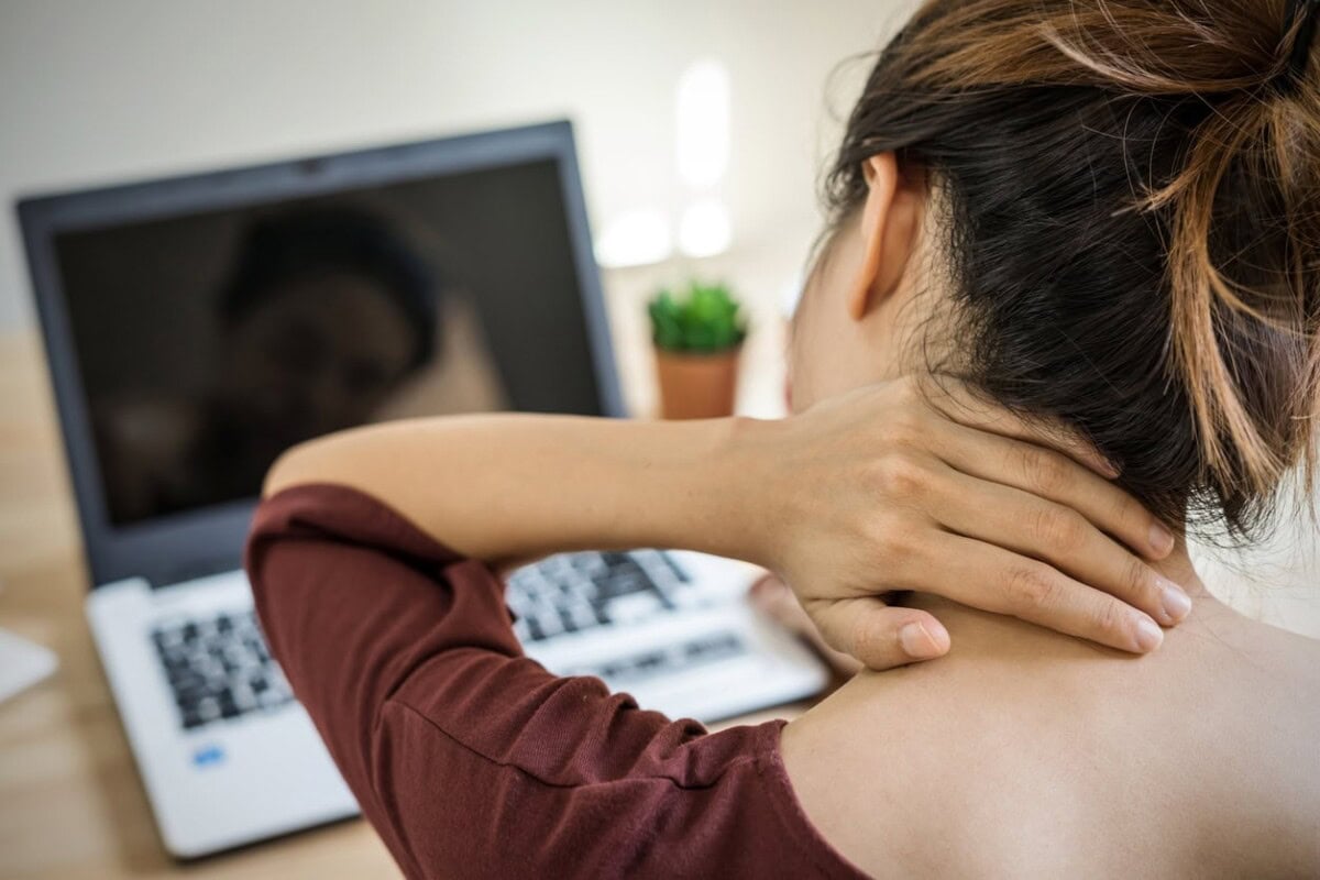 young woman working at home and having neck pain